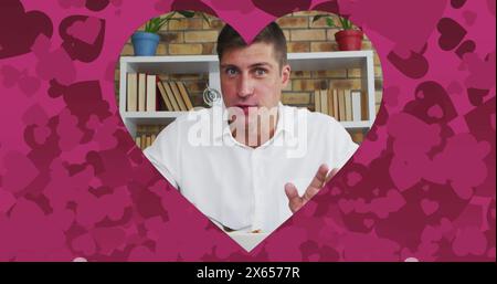 Bild eines herzförmigen Rahmens über dem kaukasischen Mann, der am Bilddatum spricht und isst Stockfoto