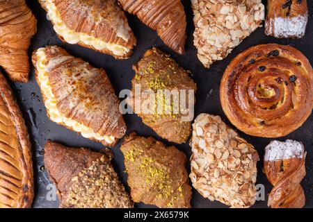 Frisch gebackenes Gebäck, Auswahl an Croissants auf dunklem Hintergrund Stockfoto