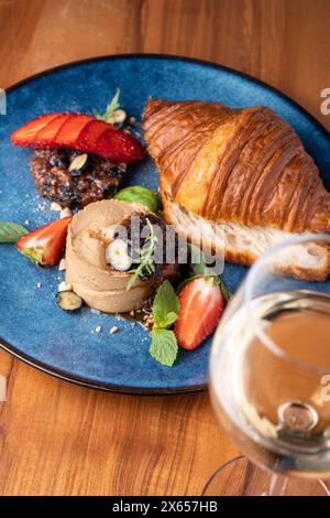 Frisch gebackenes Croissant mit Leberpastete, leckere Gourmet-Vorspeise auf dem Tisch Stockfoto