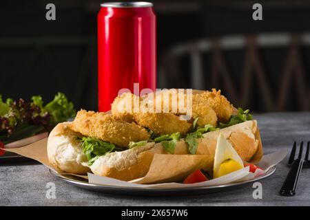 Frittierter Tintenfisch in Brot mit Gemüse an der Seite. Tintenfisch-Sandwich Stockfoto