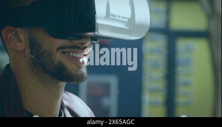 Ein birassischer junger Profi, der ein Virtual-Reality-Headset trägt, lächelt Stockfoto