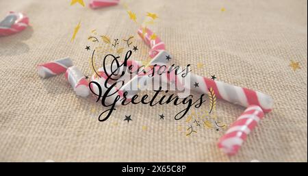 Bild von Seasons Grußtext und Sternen über Bonbons auf beigem Hintergrund Stockfoto