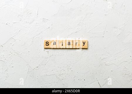 Gehaltswort auf Holzblock geschrieben. Gehaltstext auf Tabelle, Konzept. Stockfoto