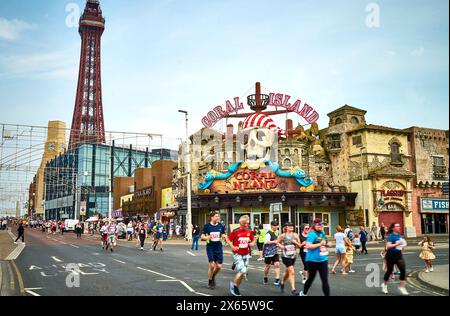 Läufer im Blackpool 10 km Fun Run (2024) passieren den Tower und Coral Island Stockfoto