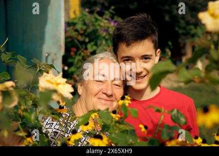 Eine ältere Frau mit ihrem Enkel im Garten Stockfoto