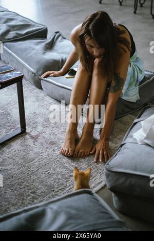 Eine junge Frau spielt mit einem Kätzchen. Stockfoto