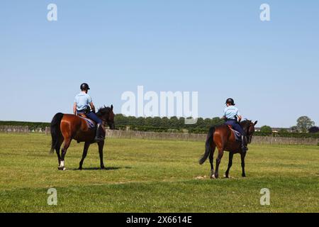 Chantilly, Frankreich - 26. Mai 2012: Gendarmen patrouillieren zu Pferd auf dem Rasen zwischen dem Hippodrom, den Großen Stallungen und dem Schloss von Chanti Stockfoto