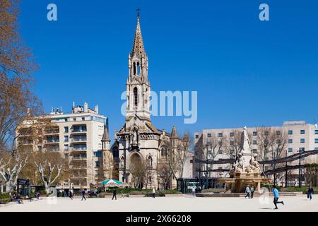 Nîmes, Frankreich - 21. März 2019: Die Esplanade von Nimes mit dem Pradier-Brunnen und der Kirche Sainte-Perpétue und Sainte-Félicité (französisch: Eglise Sai) Stockfoto