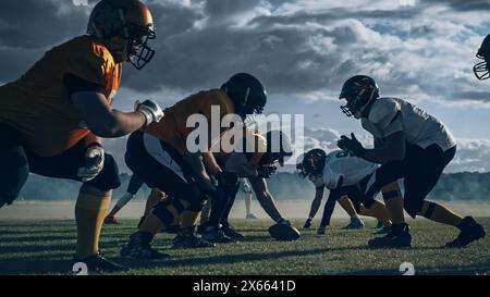 Zwei professionelle American Football-Teams stehen einander gegenüber und sind bereit, das Spiel zu starten. Verteidigung und Offensive bereite dich auf den Kampf um den Ball vor, mit dem Wunsch, Punkte zu sammeln und das Tor und den Sieg zu gewinnen. Stockfoto