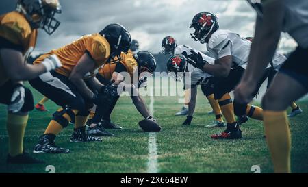 American Football Championship. Teams bereit: Professionelle Spieler, aggressiv gegeneinander, bereit zum Pushen, Tackling. Wettbewerb voller brutaler Energie, Macht. Mit dramatischem Licht aufgenommen Stockfoto