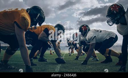 Zwei professionelle American Football-Teams stehen einander gegenüber und sind bereit, das Spiel zu starten. Verteidigung und Offensive bereite dich auf den Kampf um den Ball vor, mit dem Wunsch, Punkte zu sammeln und das Tor und den Sieg zu gewinnen. Stockfoto