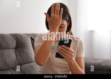 Digitaler Diebstahl. Die verzweifelte Frau findet heraus, dass ihre Kreditkarte geklont und ihr Bankkonto geleert wurde. Cybersicherheitskonzept. Stockfoto