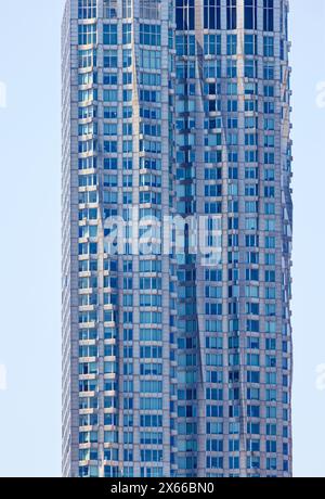 Fassadendetail der 8 Spruce Street, früher bekannt als New York von Gehry, einem mit Edelstahl verkleideten Wohnturm in Lower Manhattan. Stockfoto