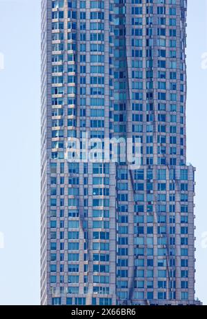 Fassadendetail der 8 Spruce Street, früher bekannt als New York von Gehry, einem mit Edelstahl verkleideten Wohnturm in Lower Manhattan. Stockfoto