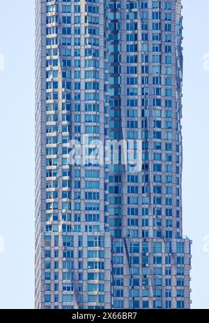 Fassadendetail der 8 Spruce Street, früher bekannt als New York von Gehry, einem mit Edelstahl verkleideten Wohnturm in Lower Manhattan. Stockfoto