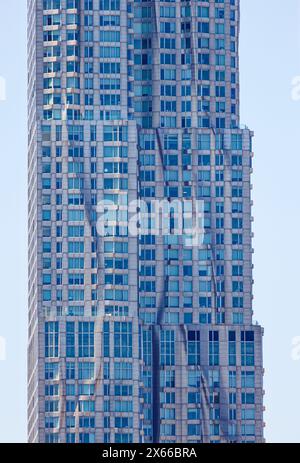 Fassadendetail der 8 Spruce Street, früher bekannt als New York von Gehry, einem mit Edelstahl verkleideten Wohnturm in Lower Manhattan. Stockfoto