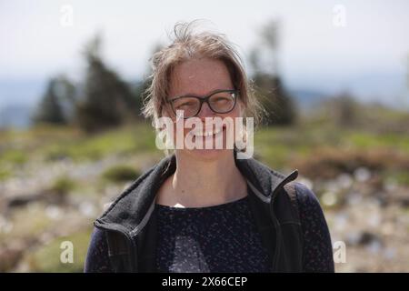 Schierke, Deutschland. Mai 2024. Katja Osterloh, Direktorin des Brockengartens, steht im einzigen Almgarten Sachsen-Anhalts am Brocken. Der 1890 gegründete Brockengarten beginnt seine neue Saison. Es gibt täglich Führungen durch den Garten, in dem 1500 Alpenpflanzen aus allen Regionen der Welt leben. Quelle: Matthias Bein/dpa/Alamy Live News Stockfoto