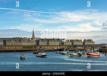 Stadtbild von Saint-Malo mit farbenfrohen Fischerbooten im Hafen und der historischen ummauerten Stadt im Hintergrund, Ille-et-Vilaine, Bretagne, Frankreich Stockfoto