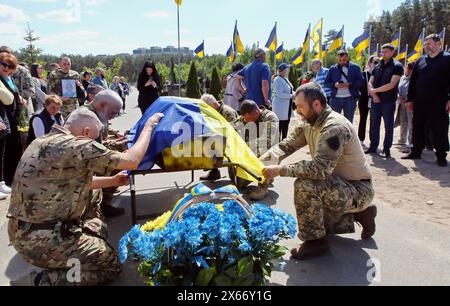 Nicht exklusiv: REGION KIEW, UKRAINE - 10. MAI 2024 - während der Beerdigungszeremonie für sol bedecken Soldaten den Sarg mit der Nationalflagge der Ukraine Stockfoto