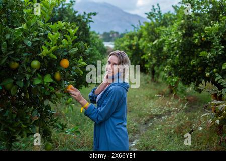 Mädchen im Garten mit Orangenfrucht Stockfoto