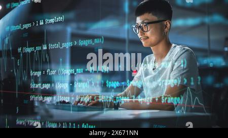 Aufnahme mit Visualisierung des ausgeführten Skriptcodes im Vordergrund. Junger Japaner, der am Desktop-Computer im Nachtbüro arbeitet. Digital Entrepreneur entwickelt moderne Software, E-Commerce App Design. Stockfoto