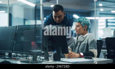Teamwork in diversen Büros: Projektmanager spricht mit Creative Solutions Specialist und diskutiert Design Shows Desktop Computer. Profis erstellen moderne Inhalte, E-Commerce-Strategie für soziale Medien Stockfoto