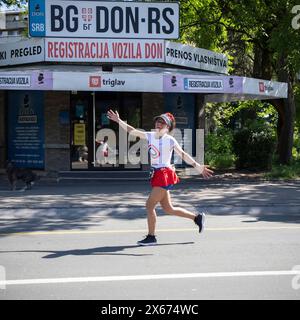 Belgrad, Serbien, 24. April 2024: Eine Marathonläuferin joggt während des 37. Belgrader Marathonrennens freudig. Stockfoto