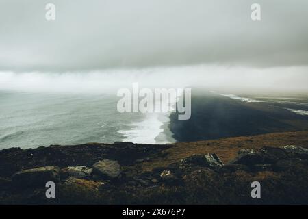 Malerische Aussicht dramatisches, beliebtes Panorama zum endlosen schwarzen vulkanischen Sandstrand vom Dyrholaey Cape, Vik, Südisland an bewölktem Tag. Vestman Stockfoto