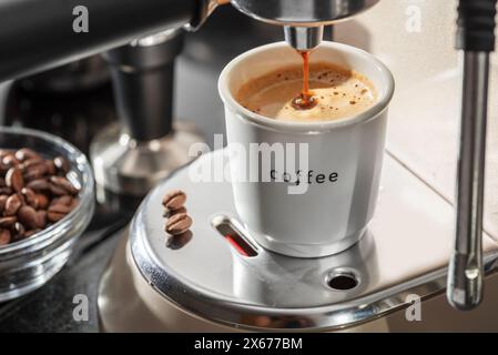 Automatische Kaffeemaschine. Gießen Sie Kaffee in die Nahaufnahme der Kaffeetasse. Stockfoto