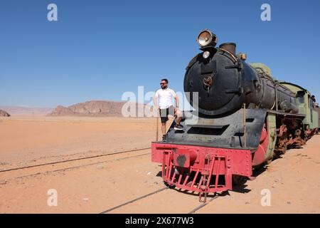 Hejaz, Wadi Rum, Jordanien – Besucher stehen auf einer Dampflokomotive ( Nippon 4-6-2 ), die von der Jordan Hedjaz Railway in der abgelegenen Wüste bei Wadi Rum betrieben wird Stockfoto