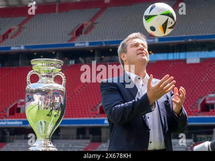 München, Deutschland. Mai 2024. Markus Söder (CSU), Ministerpräsident Bayerns, wirft bei der Verleihung der Trophäe der Fußball-Europameisterschaft einen Fußball in die Luft. Quelle: Peter Kneffel/dpa/Alamy Live News Stockfoto