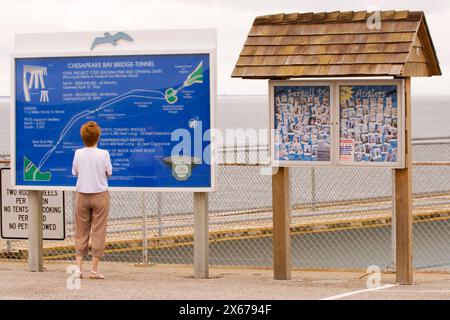 Frau liest Informationsschild an der Chesapeake Bay Bridge und Tunnel, Virginia, USA. Stockfoto