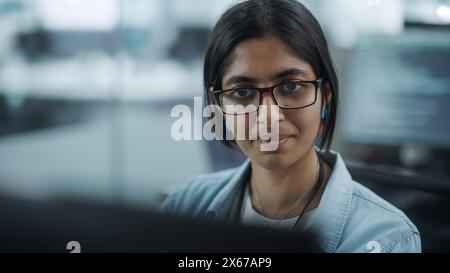 Diverse Büros: Porträt eines befähigten indischen IT-Programmierers, der auf Desktop-Computern arbeitet. Spezialist Für Frauen, Die Brillen Tragen, Entwickeln Innovative Software. Professionelle Ingenieure Entwickeln Inspirierende App Stockfoto