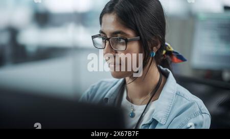 Diverse Büros: Porträt eines selbstbewussten indischen IT-Programmierers, der auf Desktop-Computern arbeitet. Spezialist Für Frauen, Die Brillen Tragen, Entwickeln Innovative Software. Professionelle Ingenieure Entwickeln Inspirierende App Stockfoto
