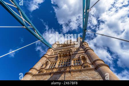 Blick von unten in Perspektive und Nadirebene auf Londons Tower Bridge, beleuchtet von der Sonne und mit den Schatten der Stahlseile an der Fassade Stockfoto