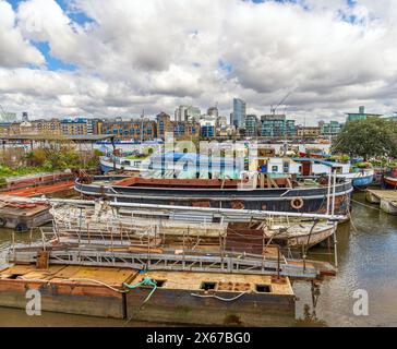 Freizeitboote und einige baufällige Boote vertäuten am Ufer der Themse an der Butler's Wharf in London, England, Großbritannien. Stockfoto