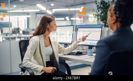 Erfahrener Manager und junger Mitarbeiter diskutieren kommerzielle, Finanz- und Marketingprojekte. Junger Direktor, der auf den Bildschirm zeigt, schimpft den Mitarbeiter im modernen Business Office. Stockfoto