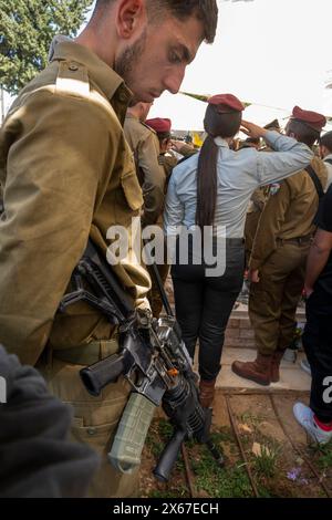 Aschkelon, Israel. Mai 2024. Ein israelischer Soldat neigt sich während einer Zeremonie zum Gedenktag in einem Friedhof in Aschkelon, Israel, am Montag, den 13. Mai 2024, den Kopf, während ein zweiminütiger Sirenenton ertönt. Israel setzt seinen Feldzug gegen die Hamas im Gazastreifen sieben Monate nach den Anschlägen vom 7. Oktober 2023 fort. Foto von Jim Hollander/UPI Credit: UPI/Alamy Live News Stockfoto