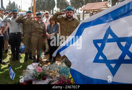 Aschkelon, Israel. Mai 2024. Israelische Soldaten und Freunde des Stabes Sergeant Daniel Kasaktschuk, 21, stehen an seinem Grab, während eine zweiminütige Sirene zum Gedenktag auf dem Friedhof Ashkelon, Israel, am 13. Mai 2024 ertönt. Israel setzt seinen Feldzug gegen die Hamas im Gazastreifen sieben Monate nach den Anschlägen vom 7. Oktober 2023 fort. Foto von Jim Hollander/UPI Credit: UPI/Alamy Live News Stockfoto