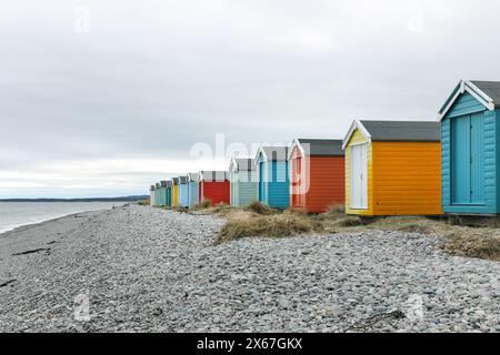 Farbenfrohe traditionelle Strandhütten an der Küste in Findhorn Bay, Moray Firth, Schottland, Großbritannien Stockfoto