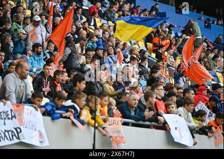 LEMBERG, UKRAINE - 11. MAI 2024 - Eine Frau hält Eine Flagge der Ukraine auf den Tribünen während des 28. Spieltags der ukrainischen Premier League 2023/24 zwischen dem FC Dynamo Kiew und dem FC Schakhtar Donetsk in der Arena Lemberg, Lwiw, Westukraine. Die Miners haben den ukrainischen Premier League-Titel 2023/24 früh mit einem 7-Punkte-Abstand und zwei Runden vor dem Ende der Meisterschaft gewonnen, da Shakhtars Mittelfeldspieler Heorhii Sudakov in der 33. Minute traf. Stockfoto