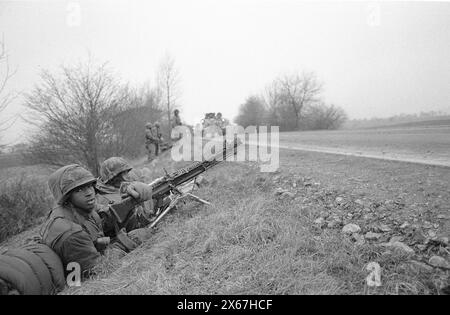 Wintermanöver, Reforger 1985, Zentralwächter, im Raum Kassel, Homberg/Efze, Neukirchen, Schwalmstadt, Vogelsberg, Frankenberg (Jan. - Feb. 1985), US-Soldaten mit Maschinengewehren, die auf die vorbeifahrende Panzerkolonne warten Stockfoto
