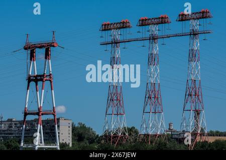 Elektrische Hochspannungsstützen mit Drähten zur Übertragung großer Mengen elektrischer Energie aus Wasserkraft für die Industrie. Industrielle Landschaft: Metalltürme zum Halten von Drähten. Stockfoto