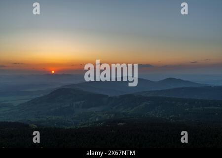 Blick vom Jested Hügel auf die frische Frühlingslandschaft mit farbenfrohem Sonnenuntergang im Norden der Tschechischen republik Stockfoto