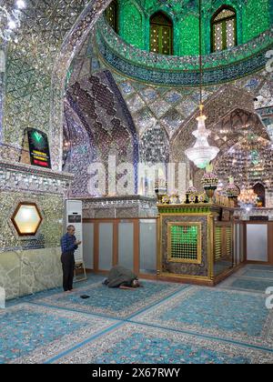 Männer beten im Ali Ibn Hamzeh Heiligtum, das im Inneren aufwendig mit glänzenden Spiegelfliesen (aina-kari) verziert ist. Shiraz, Iran. Stockfoto