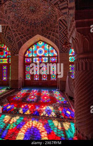 Ein Lichtspiel aus mehrfarbigen Buntglasfenstern auf Teppichboden in der Nasir al-Mulk-Moschee aus dem 19. Jahrhundert. Shiraz, Iran. Stockfoto