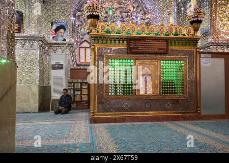 Ein Mann betet im Ali Ibn Hamzeh Heiligtum, das im Inneren aufwendig mit glänzenden Spiegelfliesen (aina-kari) verziert ist. Shiraz, Iran. Stockfoto