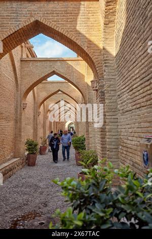 Die Menschen laufen in einer engen Gasse mit Bögen oben im historischen Zentrum von Shiraz, Iran. Stockfoto