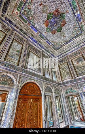Innenraum eines Zimmers mit aufwendigen Spiegelfliesen an Wänden und Decken im Qavam-Haus (Narenjestan-e Ghavam), einem historischen Haus aus dem 19. Jahrhundert. Shiraz, Iran. Stockfoto