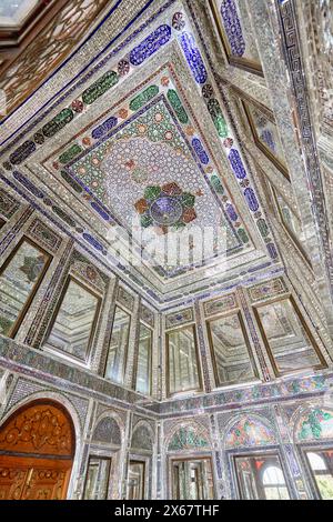 Innenraum eines Zimmers mit aufwendigen Spiegelfliesen an Wänden und Decken im Qavam-Haus (Narenjestan-e Ghavam), einem historischen Haus aus dem 19. Jahrhundert. Shiraz, Iran. Stockfoto